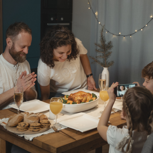 Family sitting at the dining table at home about to eat supper.